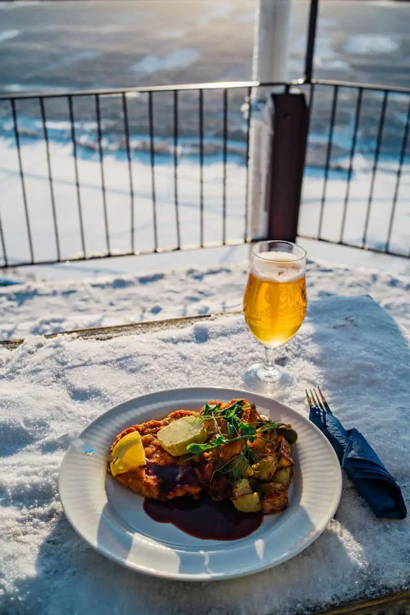 DSC07986 Gott och hälsosamt skidinspirerat måltid på en snöklädd uteplats i Funäsdalen med fjällen i bakgrunden, perfekt för en fjällsemester i Sverige.